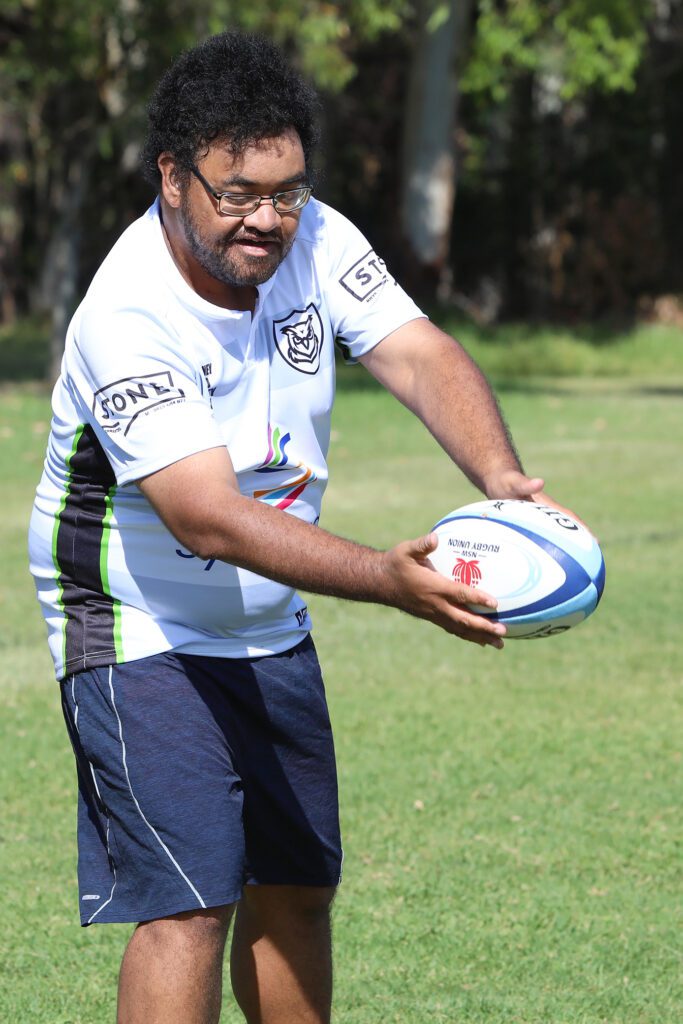 Powerful owls client smiling and catching footy