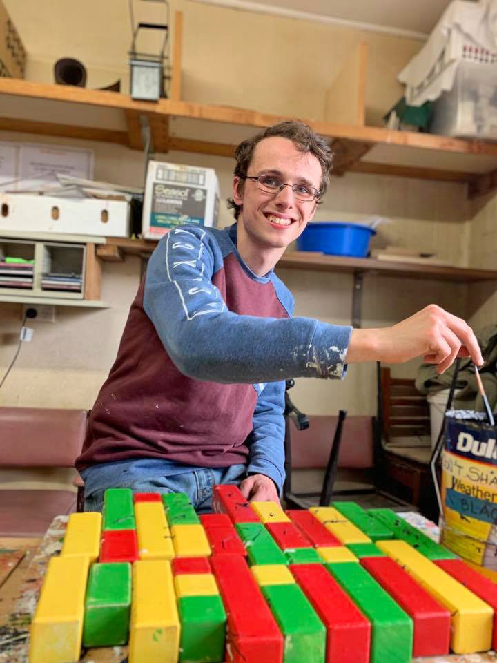 James smiling at camera while working on project