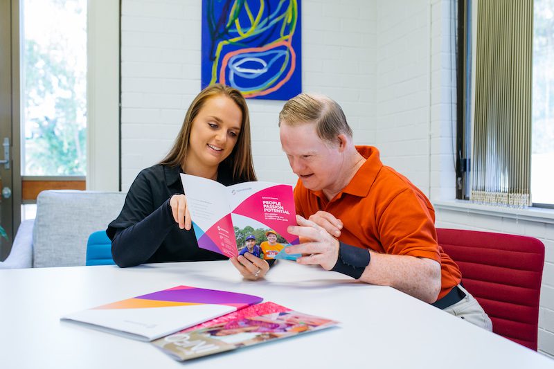 Support coordinator showing client Sylvanvale booklet